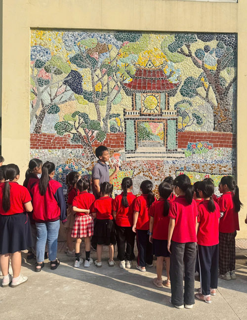 Thầy trò trường Tiểu học Liên Mạc cùng ngắm nhìn bức tranh Văn Miếu được làm từ vật liệu tái chế