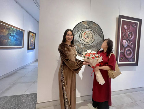 Họa sĩ Ng&ocirc; Quỳnh Li&ecirc;n b&ecirc;n t&aacute;c phẩm Thi&ecirc;n L&yacute; M&atilde; Lam Sứ